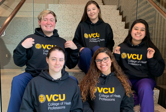 CHP students sitting on stairs wearing CHP hoodies