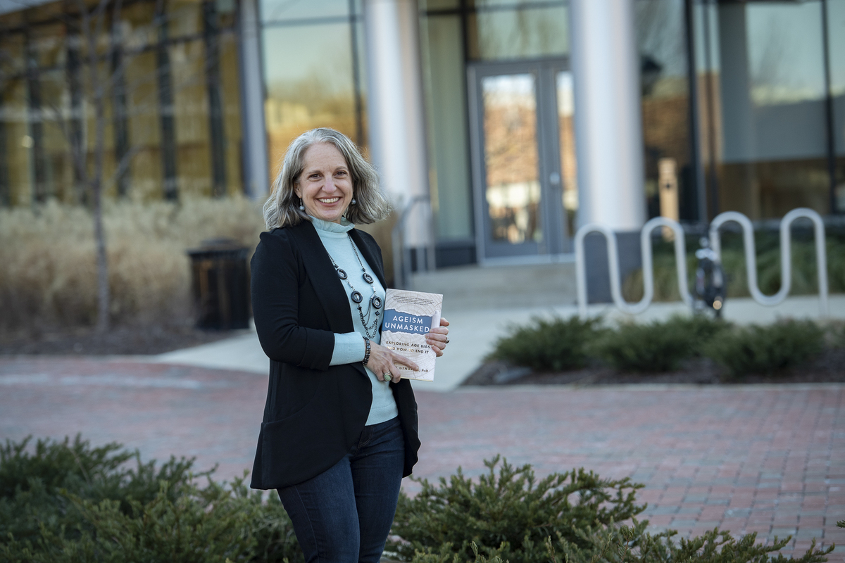 Tracey Gendron holding her new book, Ageism Unmasked: Exploring Age Bias and How to End it