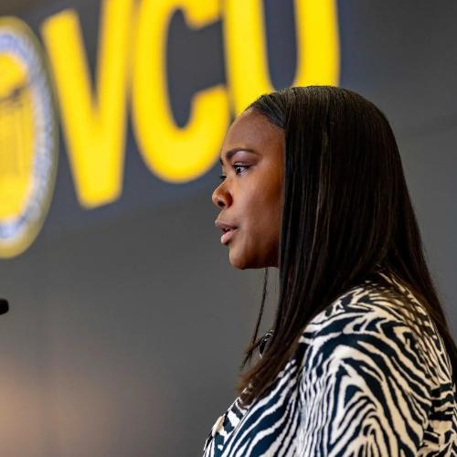 Chelsea Gary speaking at PACME Award in front of VCU sign