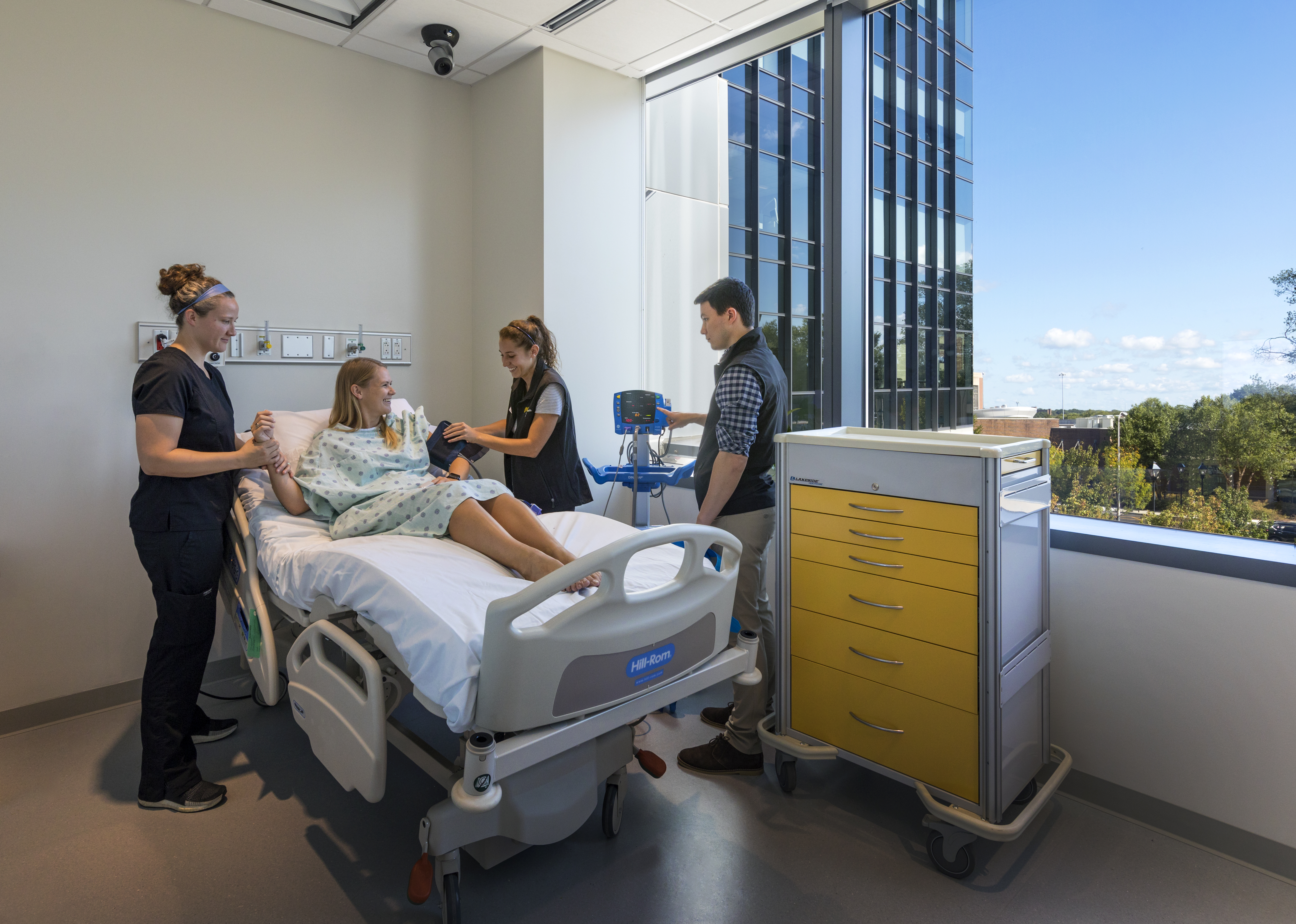 Students provide care to a patient during a simulation.