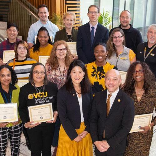 Paula Song, Stephan Davis and Angela Duncan standing with DEI team members and support 