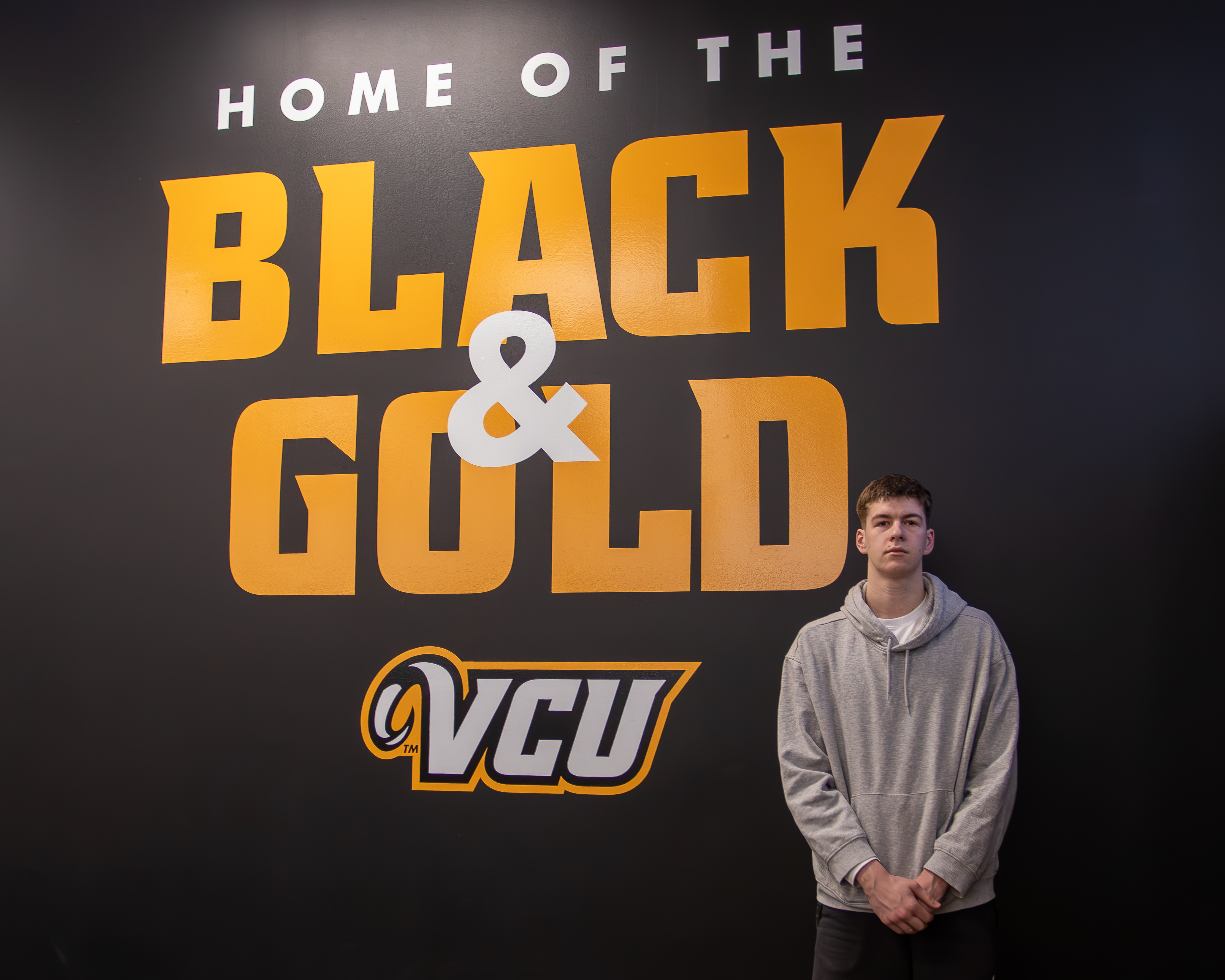 Martin Carrere standing in front of wall that says Home of the Black and Gold VCU