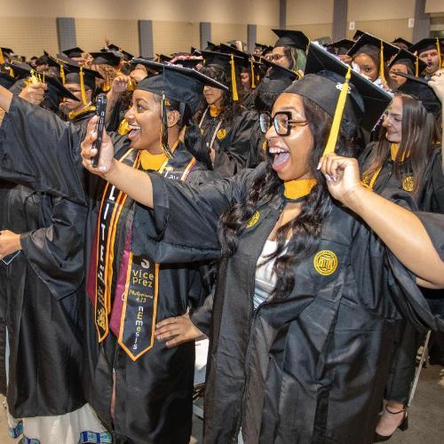 CHP graduates moving their graduation cap tassel as they graduate.