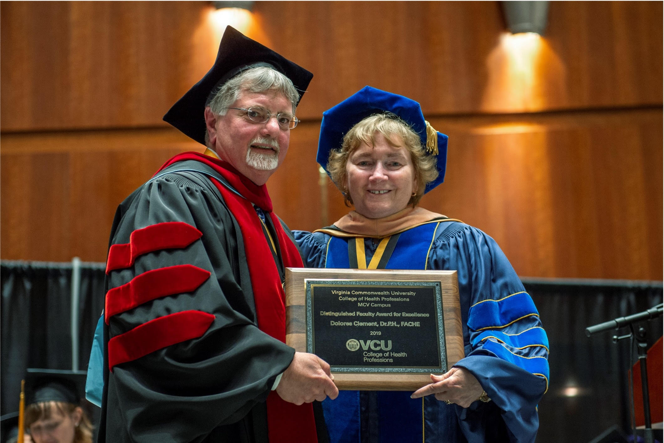 Dolores Clement being presented a faculty award by Alex Tartaglia