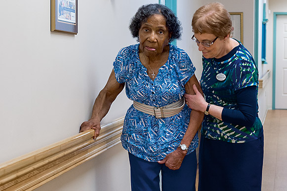 Sheila Selznick helps Mary Francis Mathiews stay ambulatory with short daily walks through the halls of Circle Center Adult Day Services.