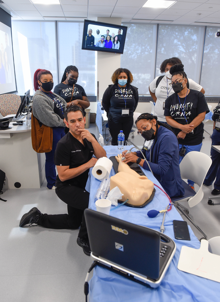 Students gathered around medical mannequin for ultrasound demonstration