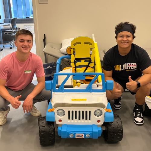 Students with the Go Baby Go car