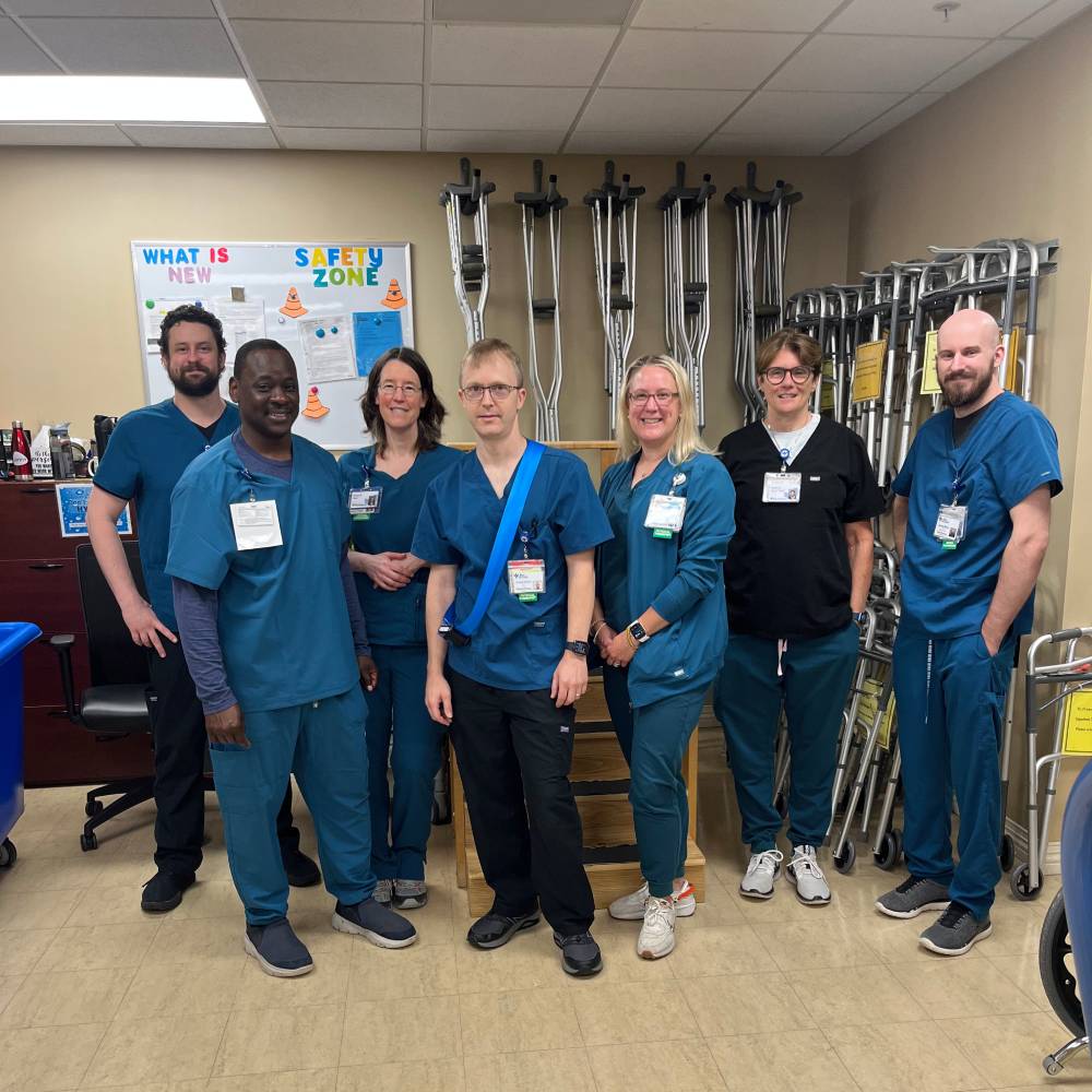 Joe Wilkins in scrubs with group of physical therapists