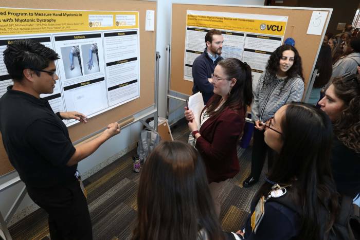Student presenting poster to audience at student research day