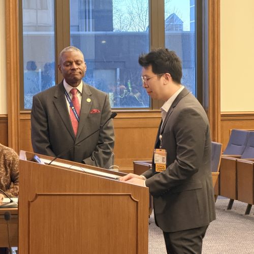 Brian Pham speaking at the podium with Delegate Thornton listening