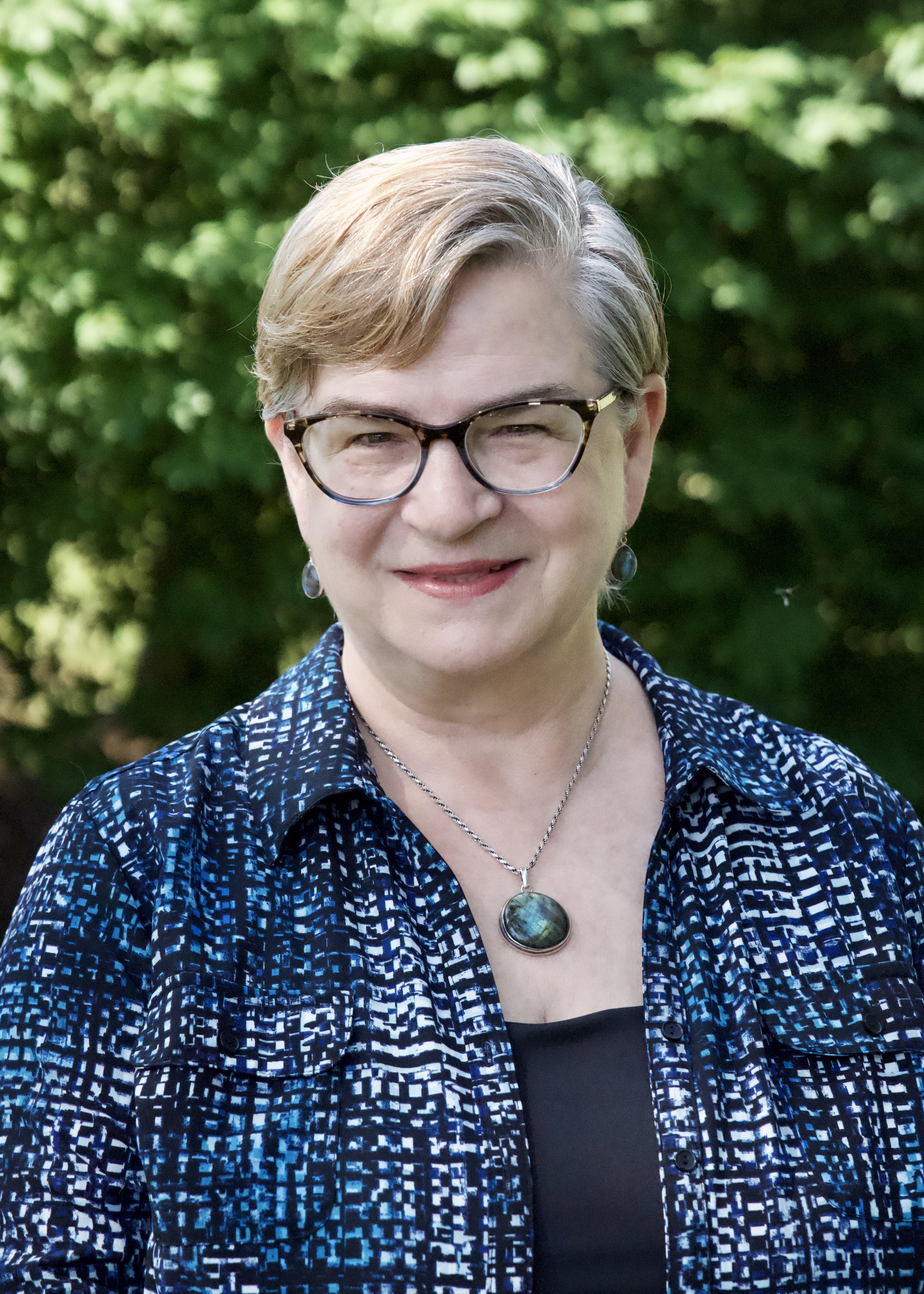 A headshot of Carri Pandolfe in glasses and a blue patterned shirt.