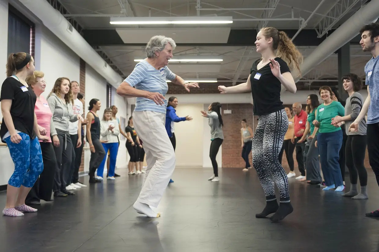 In this 2016 photo from PALETTE, an intergenerational arts program, Dorothy Schoeneman, left, dances down the soul train line with Nicole Anderson. (Photo by Steven Casanova, University Marketing)